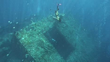 Freediver-explores-the-famous-Liberty-shipwreck-in-Tulamben,-Bali,-underwater-adventure