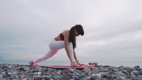 mujer practicando yoga en una playa