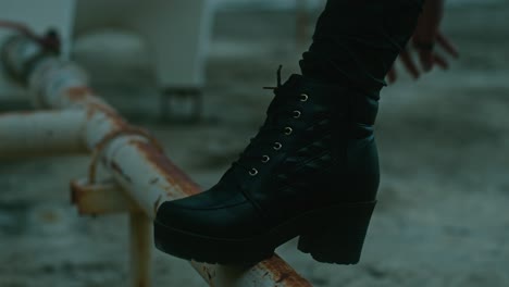 woman putting on black boots