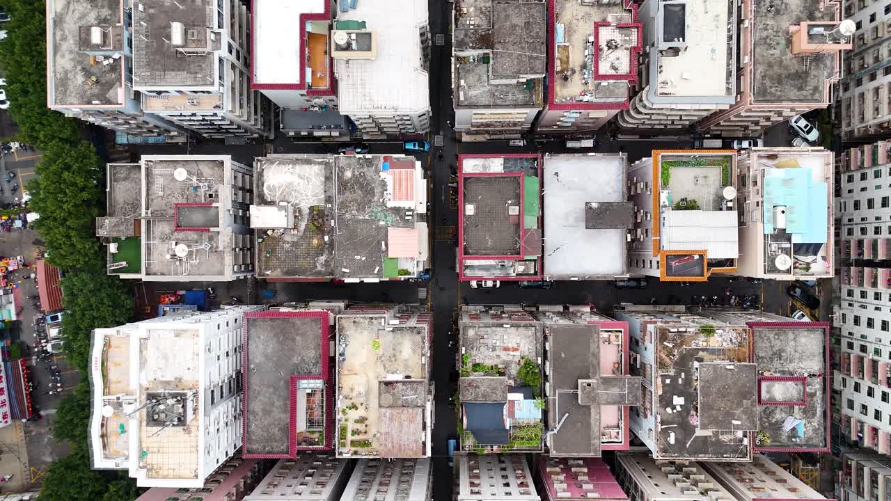 Top-down drone shot of old residential buildings in Shenzhen, China. Highlighting urban density, narrow alleys, and aging architecture in a rapidly modernizing city.