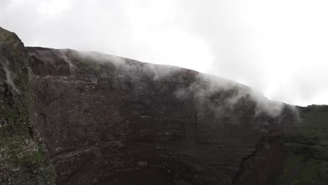 una toma escénica con vistas al cráter del monte vesubio, con niebla de nubes de lluvia bajas que cubren la cima del volcán, nápoles, italia