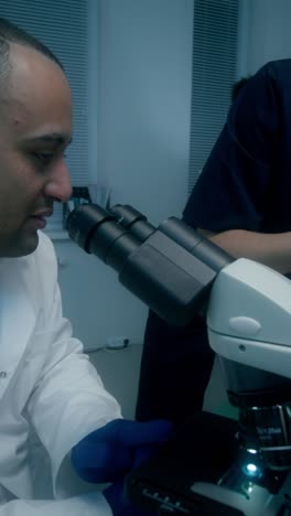 científicos trabajando con el microscopio en el laboratorio