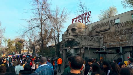 panoramic view establishing the haunted castle totally full of people, fantasilandia amusement park in santiago, chile.