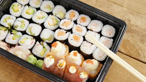 sushi rolls with salmon in plastic tray