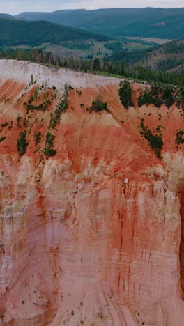 bryce national park canyons of coral color. wonderful mountainous landscape covered with pine tree forests. aerial view. vertical video
