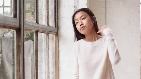 gazing out window, asian young woman reflecting quietly in living room, at home