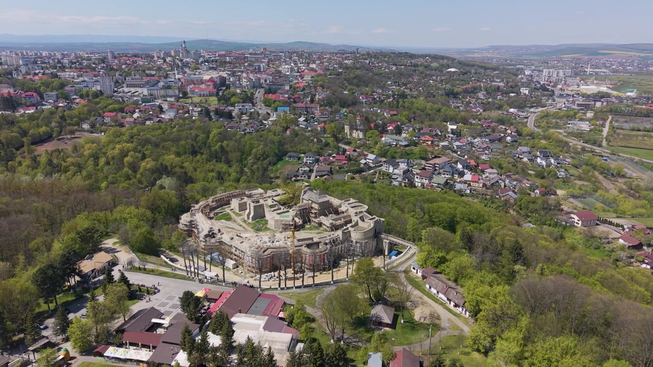 Cinematisk droneoptagelse i kredsløb omkring Suceava Fæstning med panoramaudsigt over byen og grønne bakker i Suceava, Rumænien