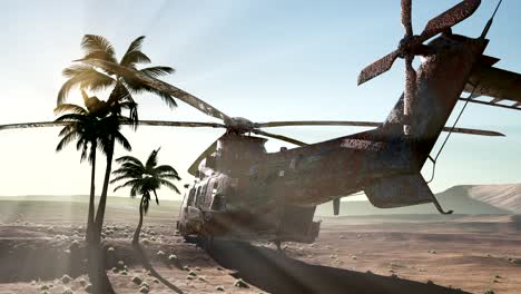 old rusted military helicopter in the desert at sunset