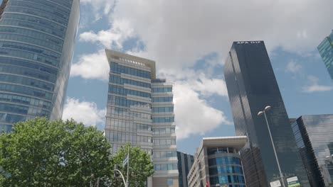 tall buildings in the city with a blue sky and clouds