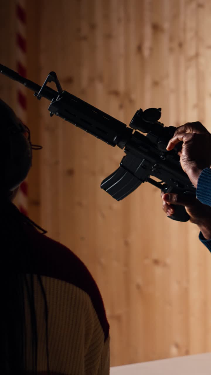 Vertical video Group of friends in firing range shooting targets, wearing earmuffs