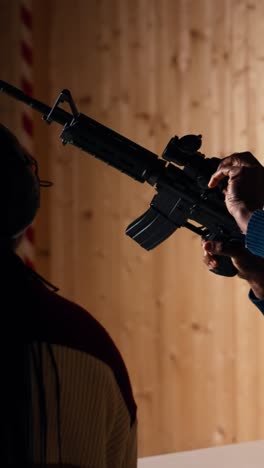 vertical video group of friends in firing range shooting targets, wearing earmuffs