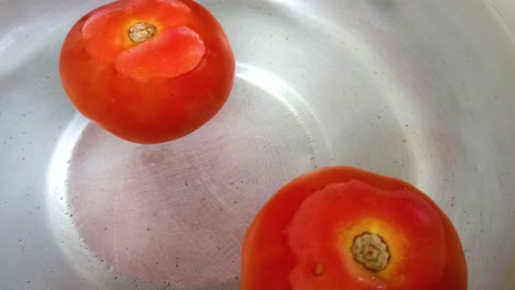 물 위에 떠다니는 두 개의 토마토의 가까운