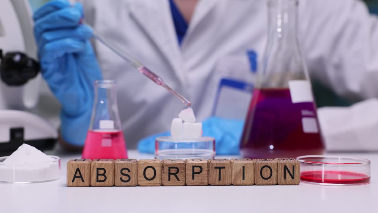 Lab worker uses pipette to apply liquid onto cubeshaped material