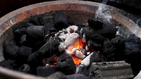 glowing coal with rising smoke in fireplace close up