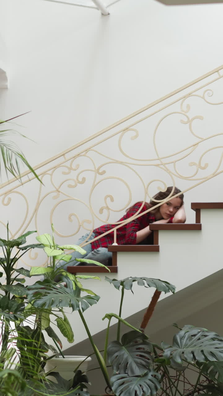 una mujer joven con un colapso emocional yace en la escalera. una mujer deprimida sufre de un trastorno de salud mental en casa. necesita tratamiento psicológico