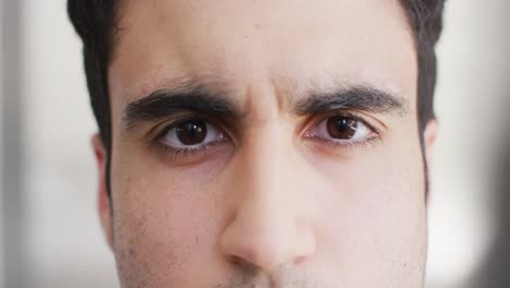 video close up portrait of the opening and blinking eyes of biracial male doctor