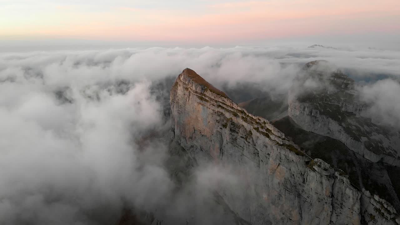 Aerial view of Tour d'A&iuml; in Leysin, Vaud, Switzerland during a colorful autumn sunset with hikers and climbers enjoying the view above clouds with Tour de Mayen in the background