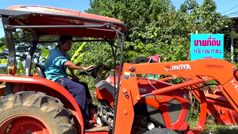 tractor moving along a lush roadside