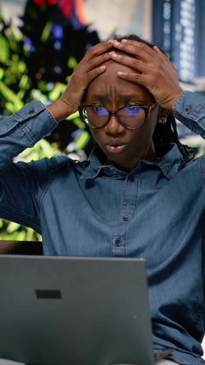 Vertical Video Concerned black woman struggling to meet deadlines with laptop