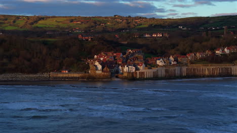 establishing drone shot of robin hood's bay at first light winter morning