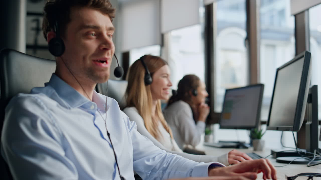 Smilende telemarketingagent snakker på kontoret. Vennlig og profesjonelt team hjelper.