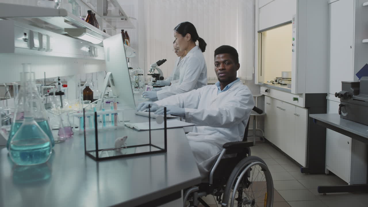 Male Scientist in Wheelchair Working in Lab and Posing