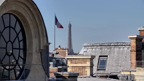 telhado de janela redonda parisiense com torre eiffel e bandeira tricolor francesa à distância, tiro alto bloqueado