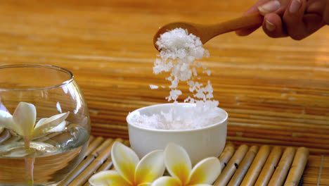 salt scrub pouring into bowl at the spa