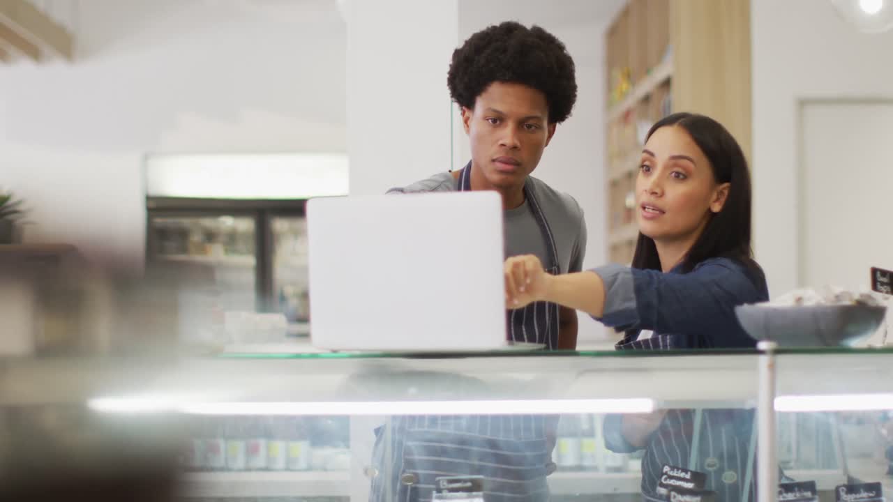 Animation of diverse female and male waiters using laptop at coffee shop