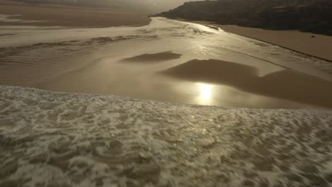 ocean to beach golden light in portugal drone footage, foz do lizandro