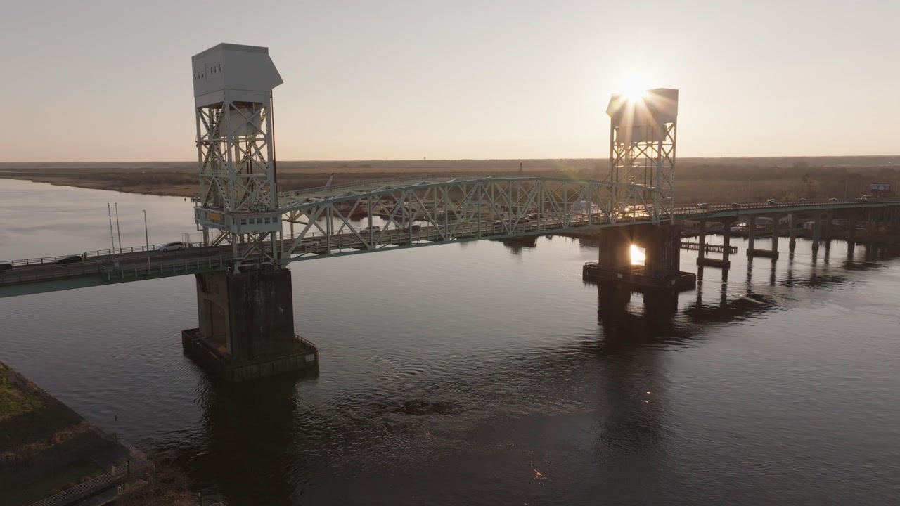 4k drone shot tracking up an iconic bridge with bustling cars revealing a golden sunset