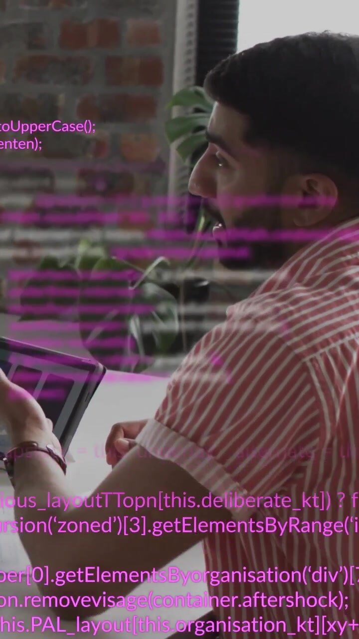 Vertikal video: Mand tapper på tablet, mens en kollegas hånd skaber et magenta kode-overlay under en teknisk gennemgang.