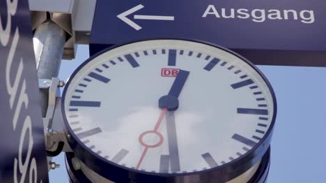 primer plano de un reloj de deutsche bahn en una estación de tren bajo un cielo despejado