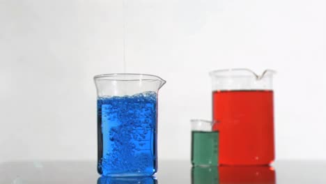 Animation-of-three-beakers-filled-with-chemical-against-grey-background