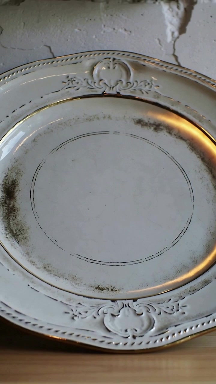 Video verticale: La telecamera che mostra un piatto su uno scaffale di legno in casa, rivelando patina e bagliore