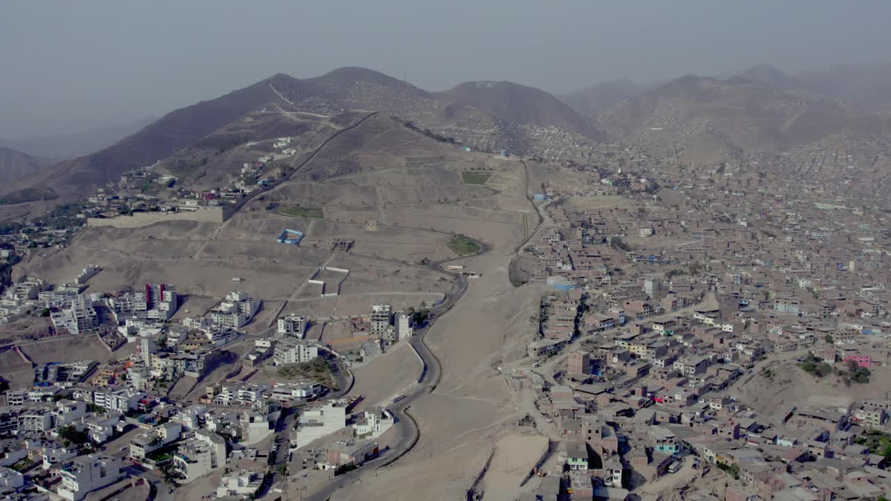 Vista aerea di una città tentacolare e baraccopoli su pendii aridi