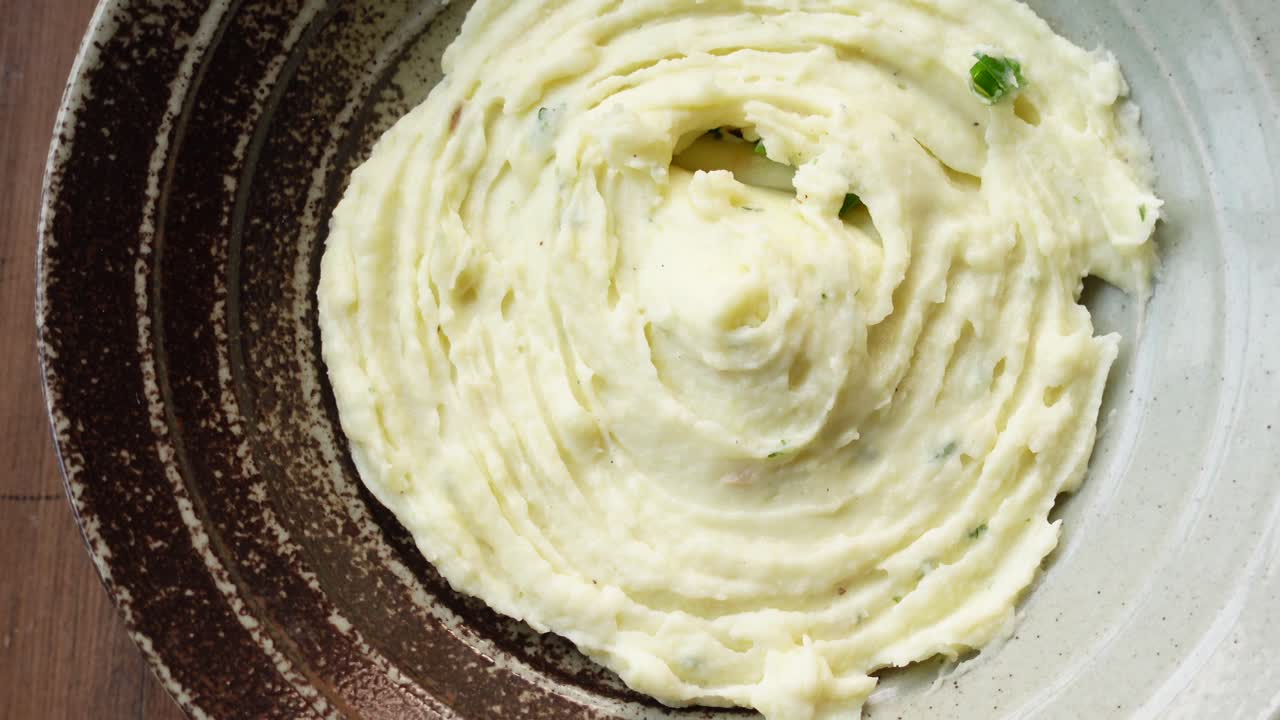 Mashed potatoes in bowl on wooden rustic table