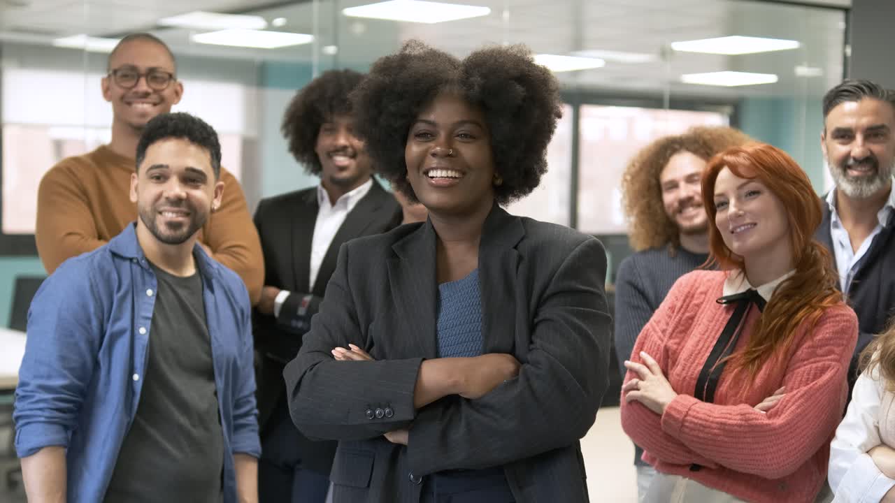 Contented manager posing with team in creative office