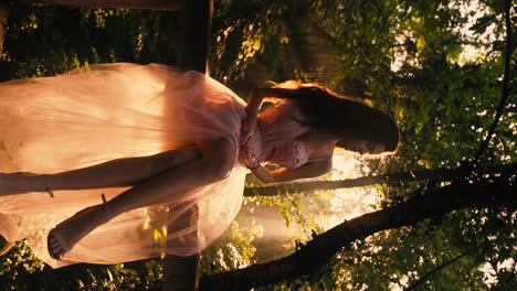 Brunette-princess-in-pink-dress-sitting-while-sun-rays-illuminate-her-in-the-dense-jungle