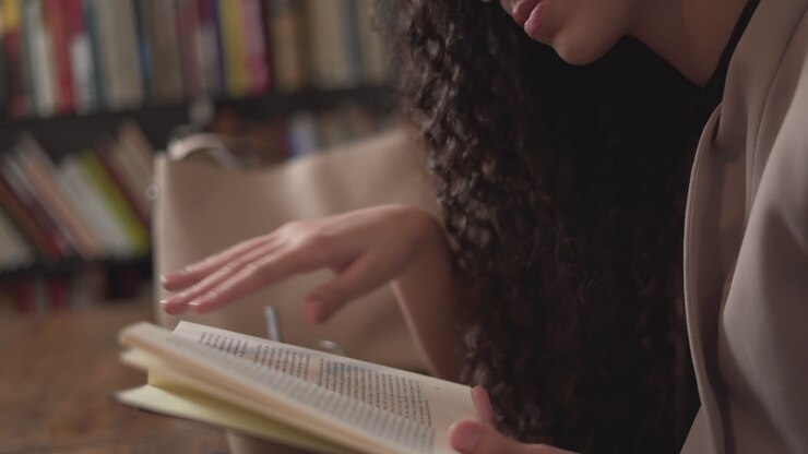 Donna che legge e prende appunti in una biblioteca