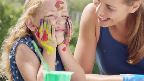 happy family  with little girl painting in the yard