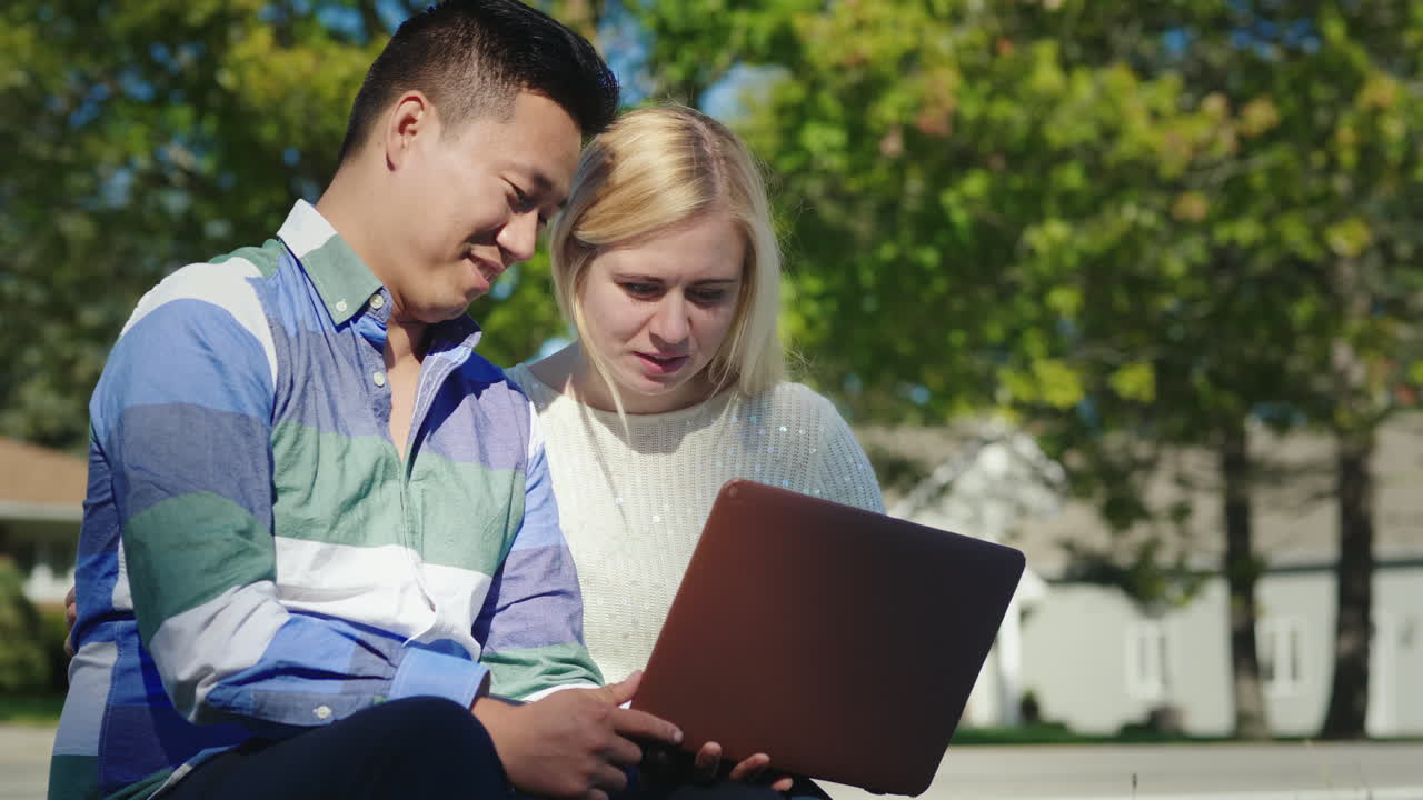 pareja usando laptop al aire libre