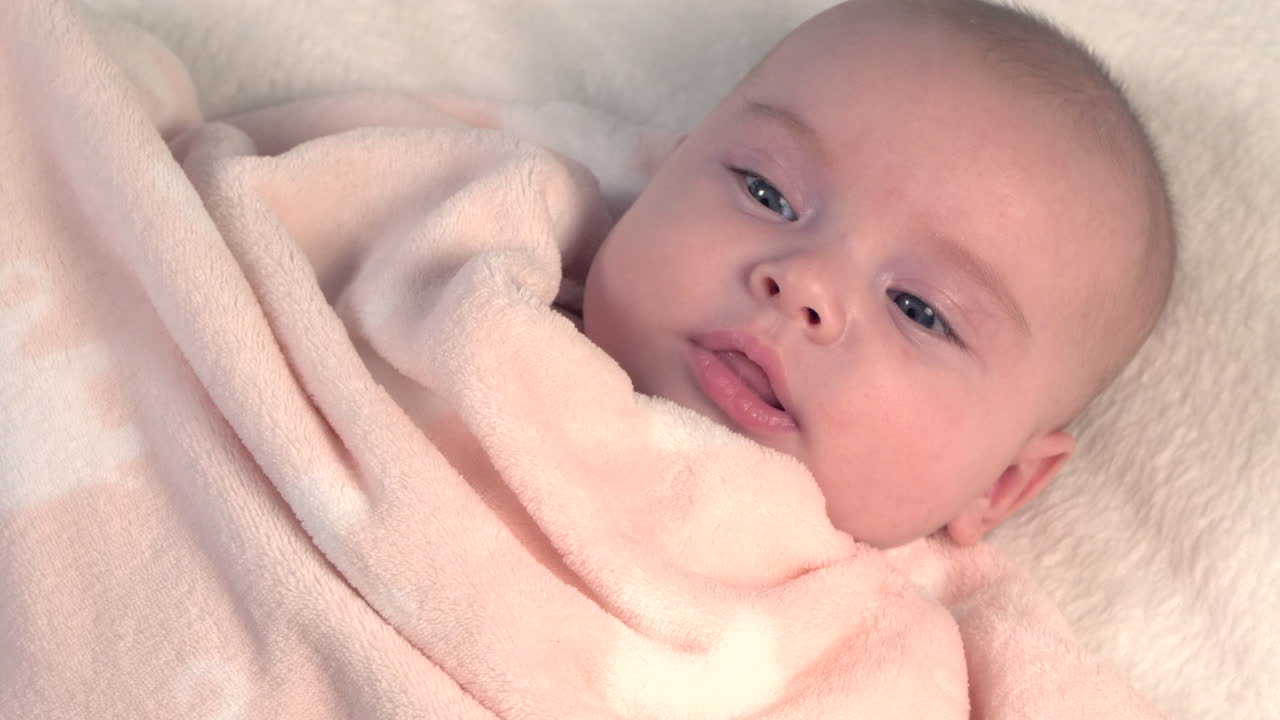 el hermoso bebé recién nacido está acostado en la cama y muestra las manos y los pies, la madre juega con el bebé y la cubre con una colcha acogedora, 4k 60p apple prores422, con grabadora de átomos externos-13