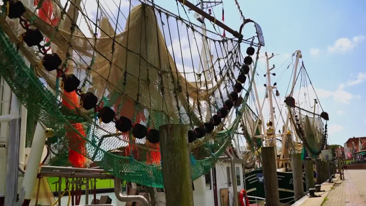 독일 북쪽 해변 에 있는 그물 을 들고 있는 어선 들 이  ⁇ 줄 을 매달아 해안 에 서 있다