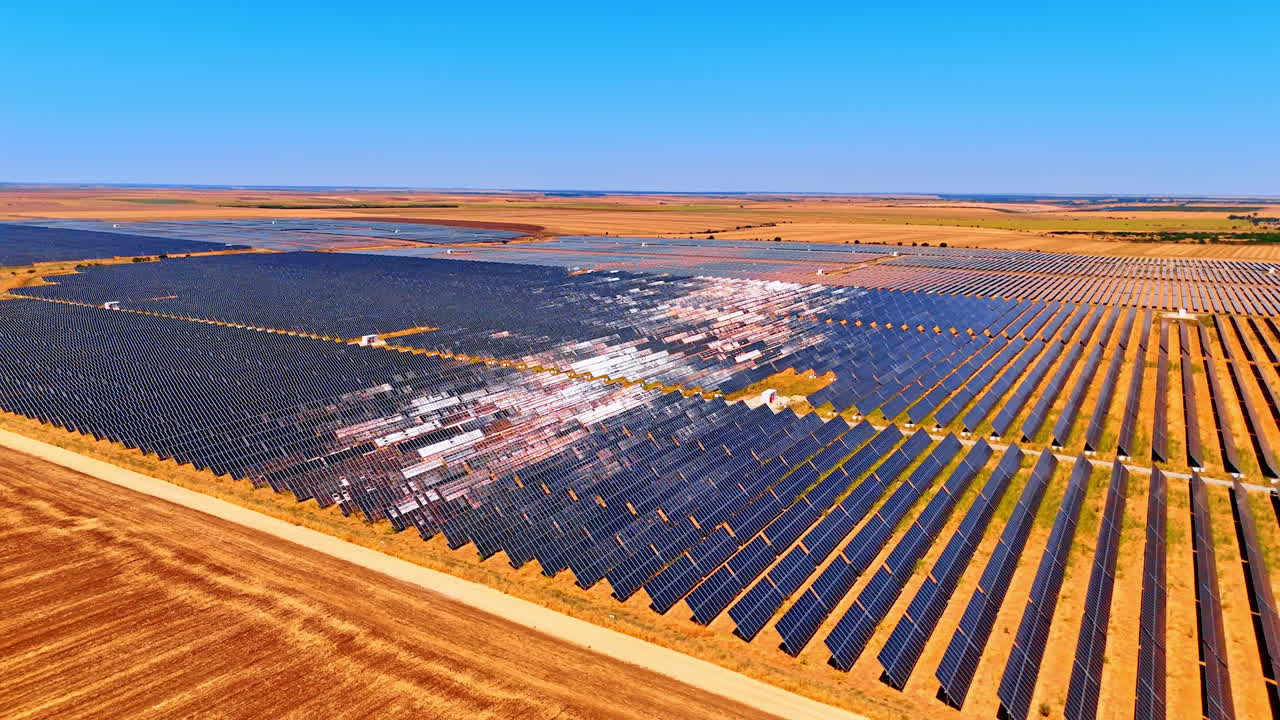 Solar panels across fields. Solar panels cover agricultural land, shining brightly under a clear blue sky