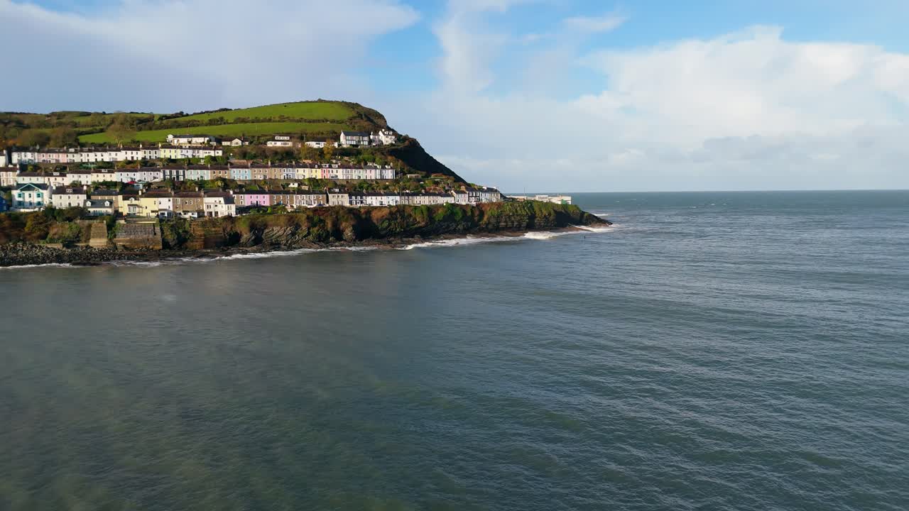 Opening establishing shot of picturesque coastal village overlooking from the sea