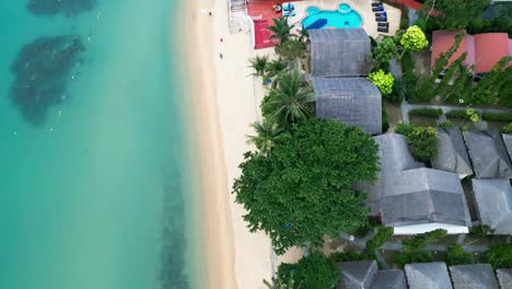 aerial bird's-eye view of mae nam beach on koh samui, featuring clear waters and tropical landscapes with luxury homes along coast