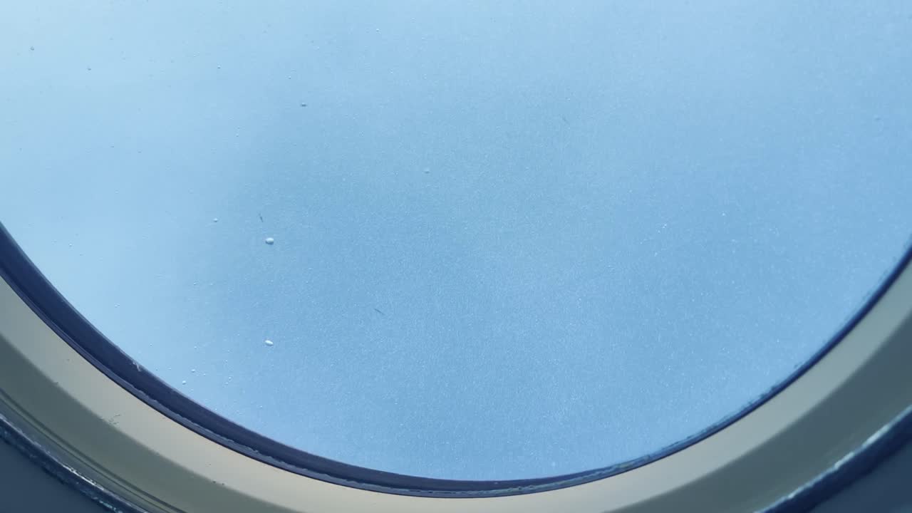 Cinematic wide shot of a flurry of air bubbles from the porthole as a submarine rises to the surface of the ocean off the coast of Hawai'i
