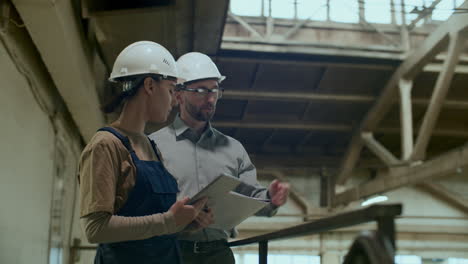 female technician and male engineer having discussion in industrial factory