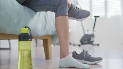 de las manos de una mujer asiática preparándose para el ejercicio, atando zapatos
